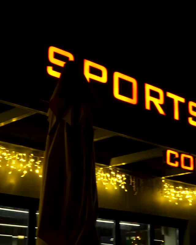 WOM Coffee'nin ışıklı Sports Club Coffee Shop tabelası ve tanıtım gecesinden salon